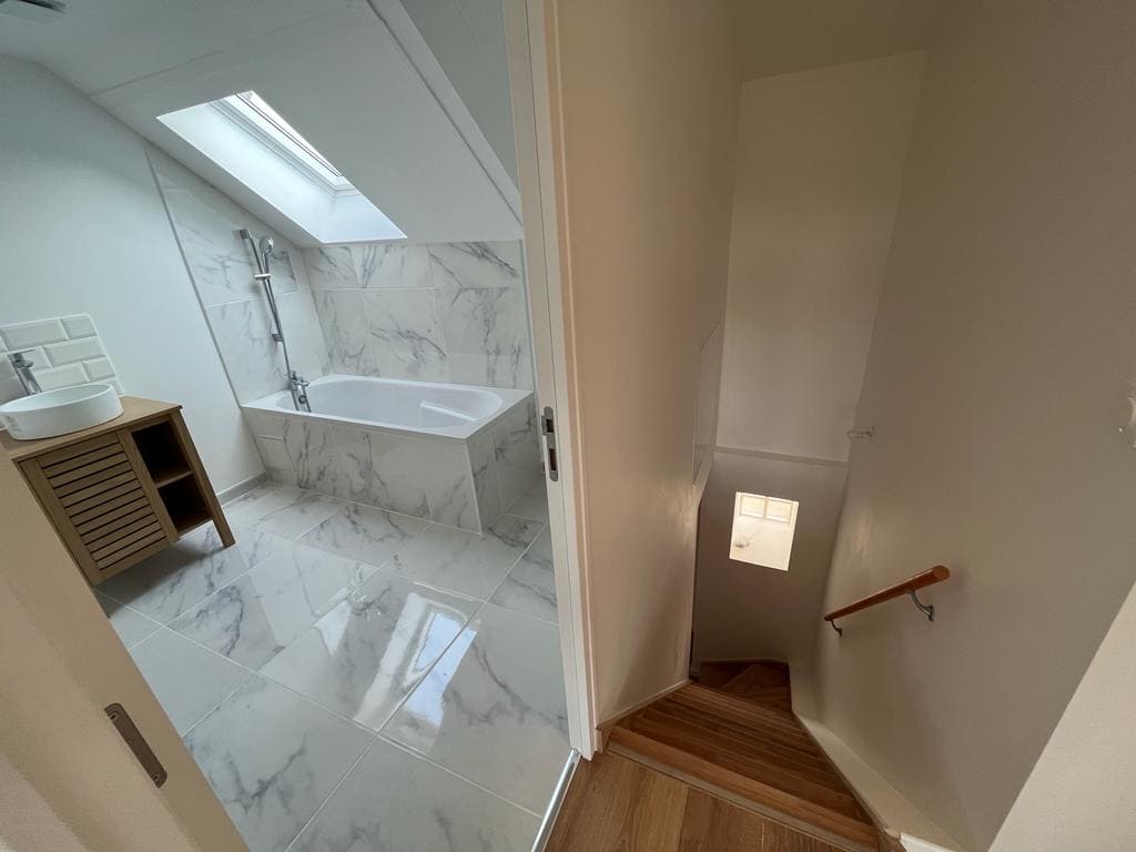Une pièce spacieuse dotée d'un escalier élégant en blanc